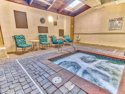 a hot tub in a patio with chairs and a table at Shores of Panama 2217- Elegantly Decorated, Sleeps 6, Free Fun! condo in Panama City Beach