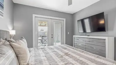 a bedroom with a bed and a flat screen tv at Blue Neptune at 5313 Sunset Avenue by Nautical Properties Vacation Rentals in Panama City Beach