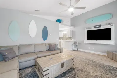 a living room with a couch and a flat screen tv at Blue Neptune at 5313 Sunset Avenue by Nautical Properties Vacation Rentals in Panama City Beach