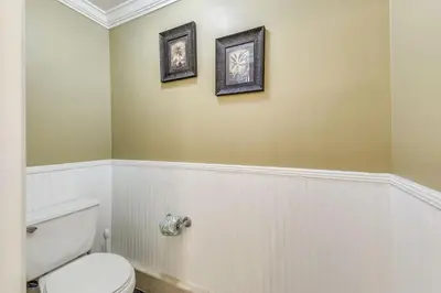 a bathroom with a toilet and two pictures on the wall at Calypso 1205 - Amazing Condo! Free Fun! Sleeps 4, Free Beach Chairs condo in Panama City Beach