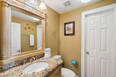 a bathroom with a sink and a mirror and a toilet at Calypso 1205 - Amazing Condo! Free Fun! Sleeps 4, Free Beach Chairs condo in Panama City Beach