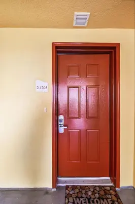 a red door in a building with a sign on it at Calypso 1205 - Amazing Condo! Free Fun! Sleeps 4, Free Beach Chairs condo in Panama City Beach