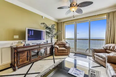 a living room with a television and a balcony at Calypso 1205 - Amazing Condo! Free Fun! Sleeps 4, Free Beach Chairs condo in Panama City Beach
