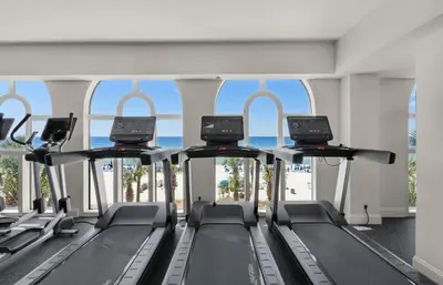 a gym with a row of treadmills at Calypso 1205 - Amazing Condo! Free Fun! Sleeps 4, Free Beach Chairs condo in Panama City Beach