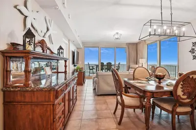 a dining room and living room with a table and chairs at Shores of Panama 401 - 4th Floor 3 Bedroom 3 Bath Sleeps 8, Same Floor Resv, Parking! Updated! condo in Panama City Beach