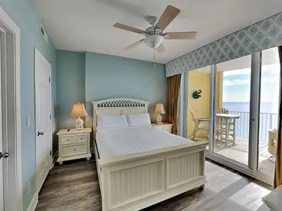 a bedroom with a bed and a balcony with the ocean at Emerald Isle Panama City Beach #2208 in Panama City Beach