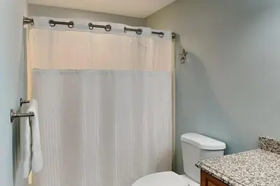 a bathroom with a white shower curtain and a toilet at Emerald Isle Panama City Beach #2208 in Panama City Beach