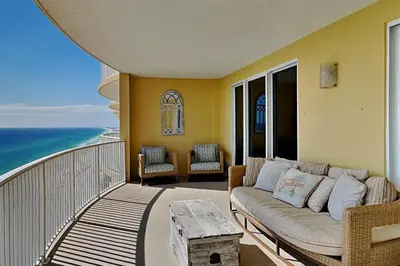a living room with a couch on a balcony with the ocean at Emerald Isle Panama City Beach #2208 in Panama City Beach