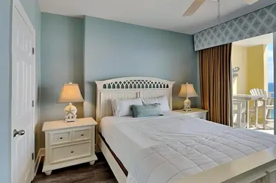 a bedroom with a white bed and two night stands with lamps at Emerald Isle Panama City Beach #2208 in Panama City Beach