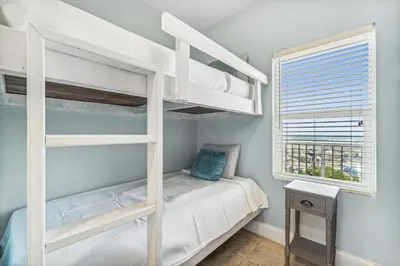 a bedroom with two bunk beds and a window at Spacious Beach Condo with Gulf Views! Sleeps 8! by Dolce Vita Getaways PCB in Panama City Beach