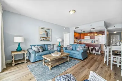 a living room with blue couches and a table at Spacious Beach Condo with Gulf Views! Sleeps 8! by Dolce Vita Getaways PCB in Panama City Beach