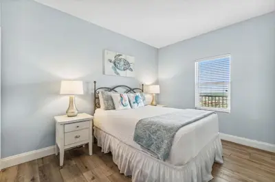 a white bedroom with a bed and a window at Spacious Beach Condo with Gulf Views! Sleeps 8! by Dolce Vita Getaways PCB in Panama City Beach