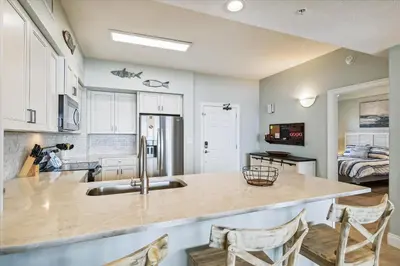 a kitchen with a sink and a counter with chairs at Gulf Crest 2005 - 2 Bedroom 2Bathroom withFantastic View! Family Friendly! Sleeps 8 condo in Panama City Beach