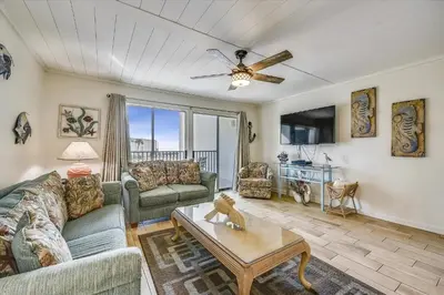 a living room with a couch and a table at Sugar Beach A6-Lovely 4 bedroom 3 bath Condo, Sleeps 11, Free Beach Chairs 2021! condo in Panama City Beach