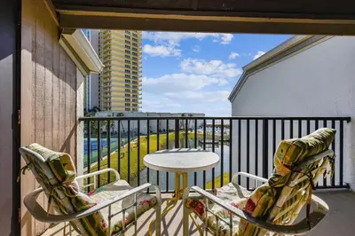 a balcony with two chairs and a table on a balcony at Sugar Beach A6-Lovely 4 bedroom 3 bath Condo, Sleeps 11, Free Beach Chairs 2021! condo in Panama City Beach