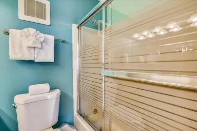a bathroom with a toilet and a glass shower at Sugar Beach A6-Lovely 4 bedroom 3 bath Condo, Sleeps 11, Free Beach Chairs 2021! condo in Panama City Beach