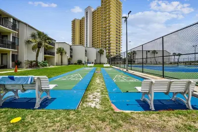 a tennis court with two benches on a tennis court at Sugar Beach A6-Lovely 4 bedroom 3 bath Condo, Sleeps 11, Free Beach Chairs 2021! condo in Panama City Beach