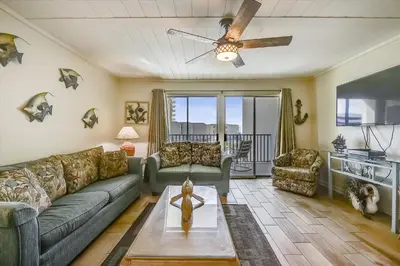 a living room with a couch and a ceiling fan at Sugar Beach A6-Lovely 4 bedroom 3 bath Condo, Sleeps 11, Free Beach Chairs 2021! condo in Panama City Beach