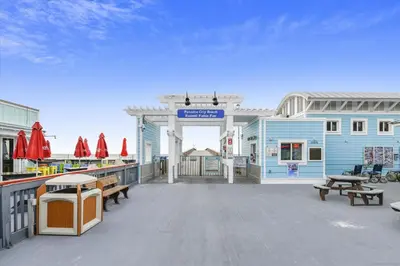a large deck with benches and a blue building at Cozy Holiday Hideaway, Sleeps 4! Steps to the Beach! Renovated 2021 condo in Panama City Beach