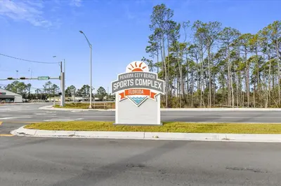 a sign for a store on the side of a road at Cozy Holiday Hideaway, Sleeps 4! Steps to the Beach! Renovated 2021 condo in Panama City Beach
