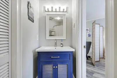 a bathroom with a blue cabinet and a sink at Cozy Holiday Hideaway, Sleeps 4! Steps to the Beach! Renovated 2021 condo in Panama City Beach