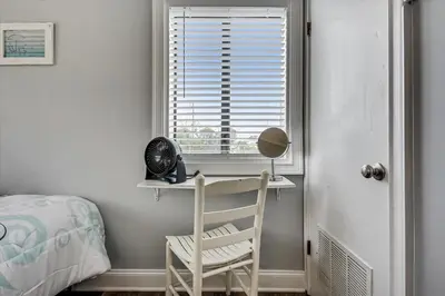 a bedroom with a desk and a window with a chair at Cozy Holiday Hideaway, Sleeps 4! Steps to the Beach! Renovated 2021 condo in Panama City Beach