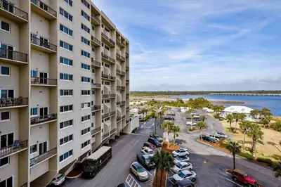 an apartment building with cars parked in a parking lot at Pinnacle Port A502 - Updated 3 Bedroom 3 Bathroom Sleeps 8, Free Fun! Boat Ramp Access! condo in Panama City Beach