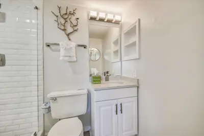 a bathroom with a toilet and a sink and a mirror at Pinnacle Port A502 - Updated 3 Bedroom 3 Bathroom Sleeps 8, Free Fun! Boat Ramp Access! condo in Panama City Beach