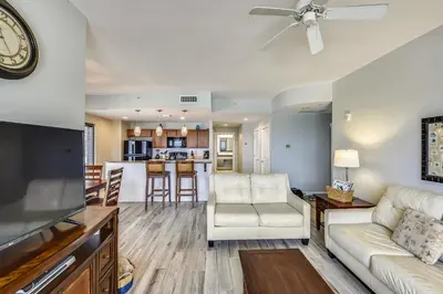 a living room with a white couch and a tv at Origin 1036, Perfect for 4! Beautiful sunset and Gulf of Mexico view! Free Activities! condo in Panama City Beach
