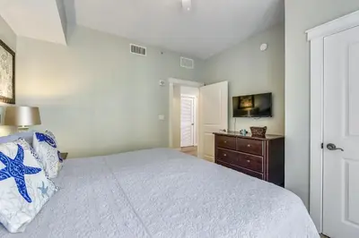 a bedroom with a bed and a dresser and a television at Origin 1036, Perfect for 4! Beautiful sunset and Gulf of Mexico view! Free Activities! condo in Panama City Beach
