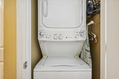 a washer and dryer in a laundry room at Shores of Panama 1506, Perfect for a Great Couples Getaway! Free Fun! Reserved Parking condo in Panama City Beach