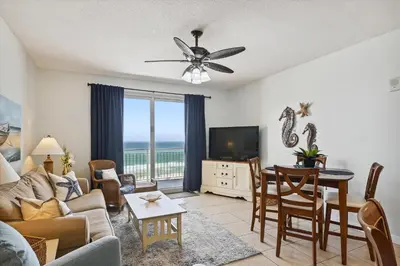 a living room with a couch and a table and a television at Sterling Reef 202 - 2nd Floor withUninterrupted Gulf View! Free Fun! Free Gas Card! condo in Panama City Beach