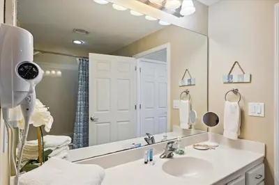 a bathroom with a sink and a large mirror at Sterling Reef 202 - 2nd Floor withUninterrupted Gulf View! Free Fun! Free Gas Card! condo in Panama City Beach