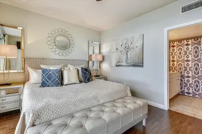 a bedroom with a large bed and a mirror at Shores of Panama 620-Sleeps 8, Free Fun! Reserved Parking Space! Updated! condo in Panama City Beach