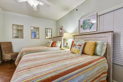 a bedroom with two beds and a ceiling fan at Shores of Panama 620-Sleeps 8, Free Fun! Reserved Parking Space! Updated! condo in Panama City Beach