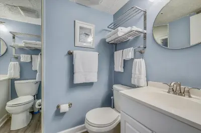 a bathroom with a toilet and a sink and a mirror at Recently renovated 2Bd, Sleeps 6 Pinnacle Port, with Boat Ramp condo in Panama City Beach
