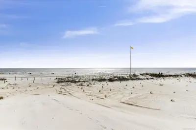 a beach with a flag in the sand at Recently renovated 2Bd, Sleeps 6 Pinnacle Port, with Boat Ramp condo in Panama City Beach
