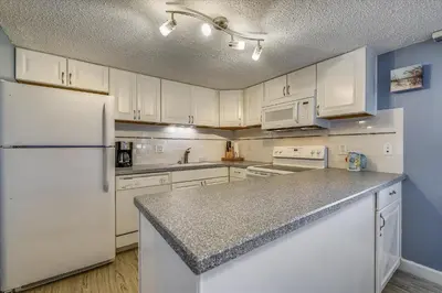 a kitchen with white cabinets and a white refrigerator at Recently renovated 2Bd, Sleeps 6 Pinnacle Port, with Boat Ramp condo in Panama City Beach