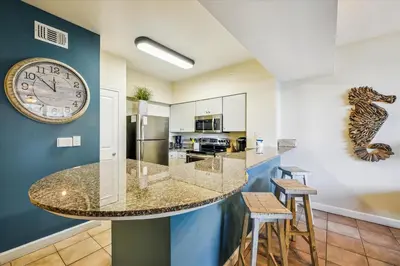 a kitchen with a large clock on the wall at Shores of Panama 316 - 3rd Floor 1 Bedroom, Sleeps 6, Reserved Parking Space, Free Daily Fun! condo in Panama City Beach