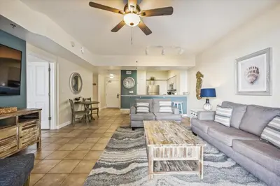 a living room with a couch and a ceiling fan at Shores of Panama 316 - 3rd Floor 1 Bedroom, Sleeps 6, Reserved Parking Space, Free Daily Fun! condo in Panama City Beach