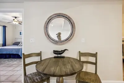 a table and chairs in a room with a mirror at Shores of Panama 316 - 3rd Floor 1 Bedroom, Sleeps 6, Reserved Parking Space, Free Daily Fun! condo in Panama City Beach