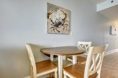 a dining room table and chairs with a painting on the wall at Laketown Wharf 1003, Gulf View, Sleeps 6, Free Fun! Updated! condo in Panama City Beach