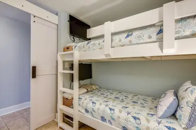 a bedroom with two bunk beds and a tv at Laketown Wharf 1003, Gulf View, Sleeps 6, Free Fun! Updated! condo in Panama City Beach