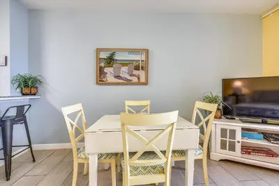 a dining room with a table and chairs and a tv at Shores of Panama 821-2 Bd 3Ba, Sleeps 8! Updated, No Carpet! Free Fun! condo in Panama City Beach