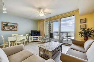 a living room with a couch and a table and a television at Shores of Panama 821-2 Bd 3Ba, Sleeps 8! Updated, No Carpet! Free Fun! condo in Panama City Beach