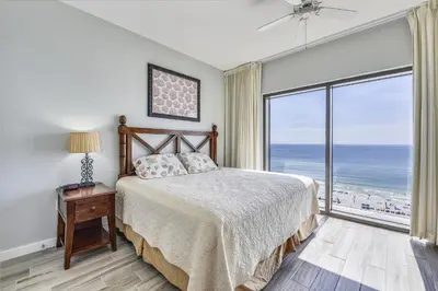 a bedroom with a bed and a large window with the ocean at Origin 1038, Sunset & Gulf View! Perfect for 2! Free Fun! condo in Panama City Beach