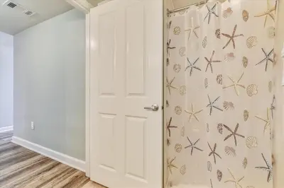 a white door with a shower curtain with butterflies on it at Shores of Panama 325 - 3rd Floor, Updated, Free Fun! Sleeps 6, condo in Panama City Beach
