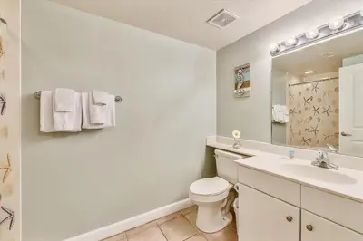 a bathroom with a toilet and a sink and a mirror at Shores of Panama 325 - 3rd Floor, Updated, Free Fun! Sleeps 6, condo in Panama City Beach