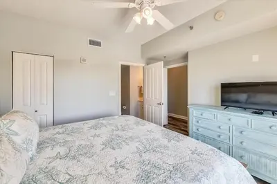 a bedroom with a bed and a dresser and a tv at Shores of Panama 325 - 3rd Floor, Updated, Free Fun! Sleeps 6, condo in Panama City Beach