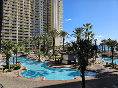 a resort pool with palm trees and a building at Shores of Panama 325 - 3rd Floor, Updated, Free Fun! Sleeps 6, condo in Panama City Beach